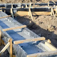 Wykonanie fundamentów: szalunek z folią i świeżym betonem.
